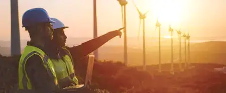 Paslanmaz çeliğin enerji alanıda üretildiğini gösteren teknisyen ve rüzgâr türbini görseli.